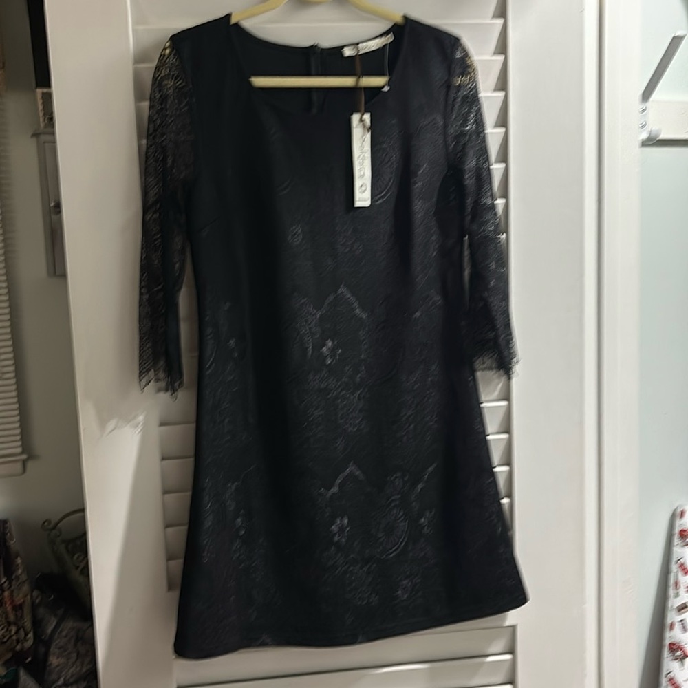Black party dress. 3/4 length sleeves and hits above the knee.